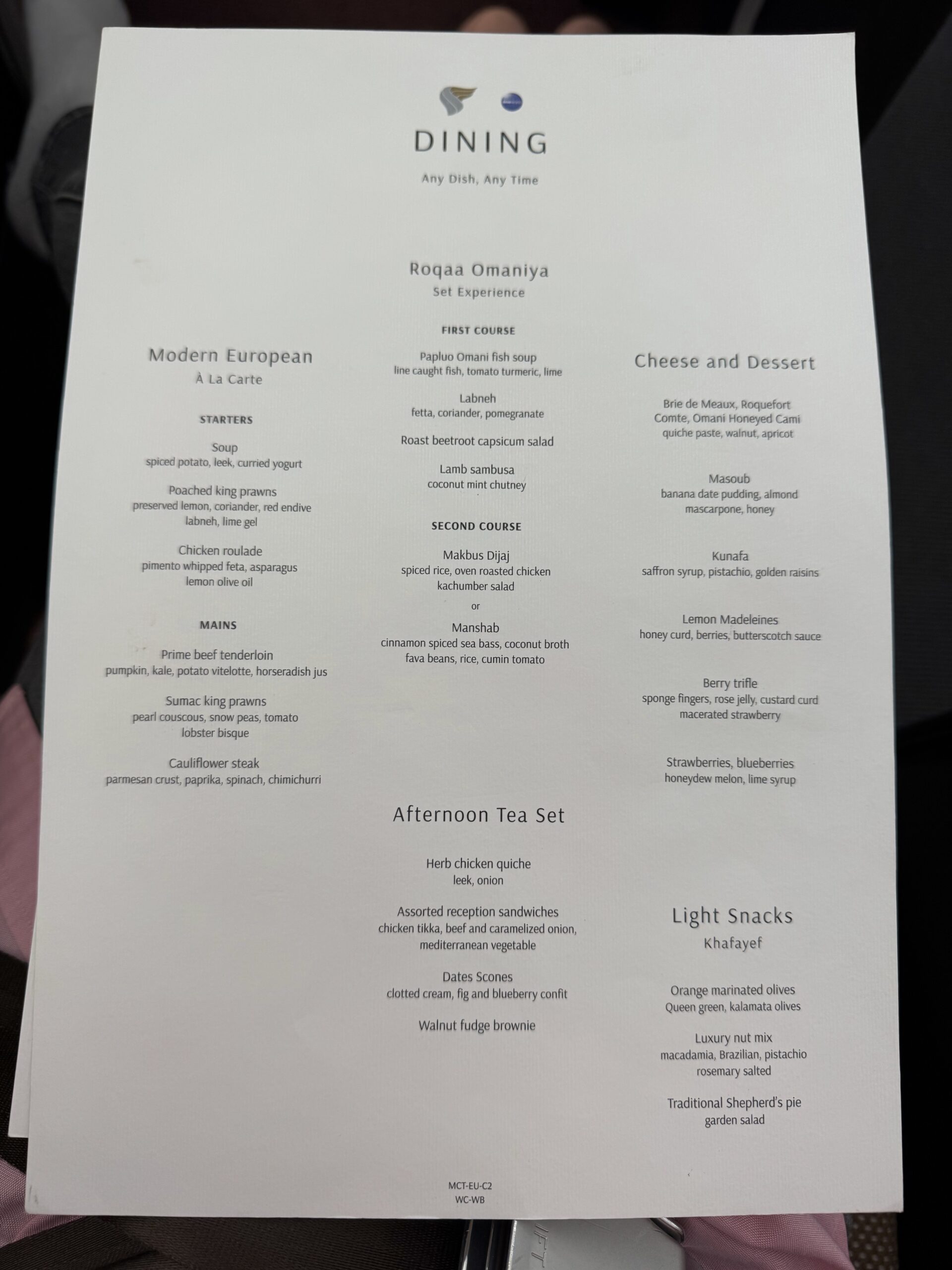 White restaurant menu card labeled DINING with sections for Modern European, Afternoon Tea Set, and Cheese and Dessert visible on the page.